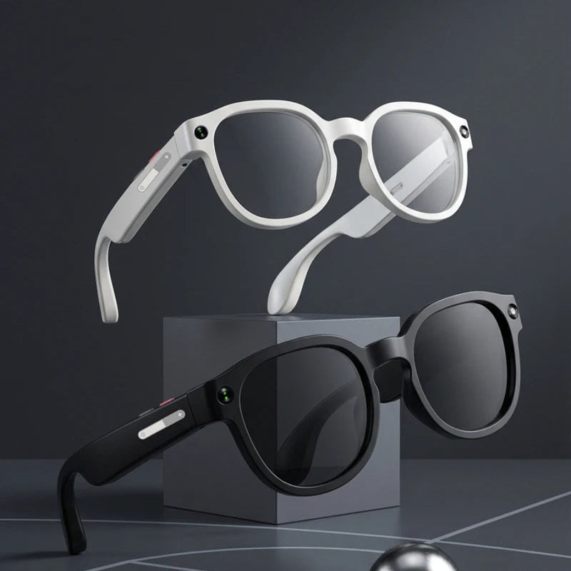 Two pairs of sunglasses, one white and one black, on a dark surface with a reflective ball.