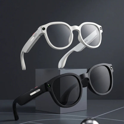 Two pairs of sunglasses, one white and one black, on a dark surface with a reflective ball.